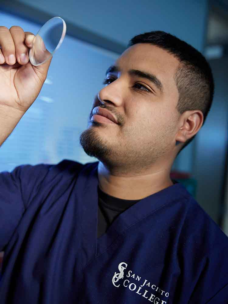 male eye care tech look at lens