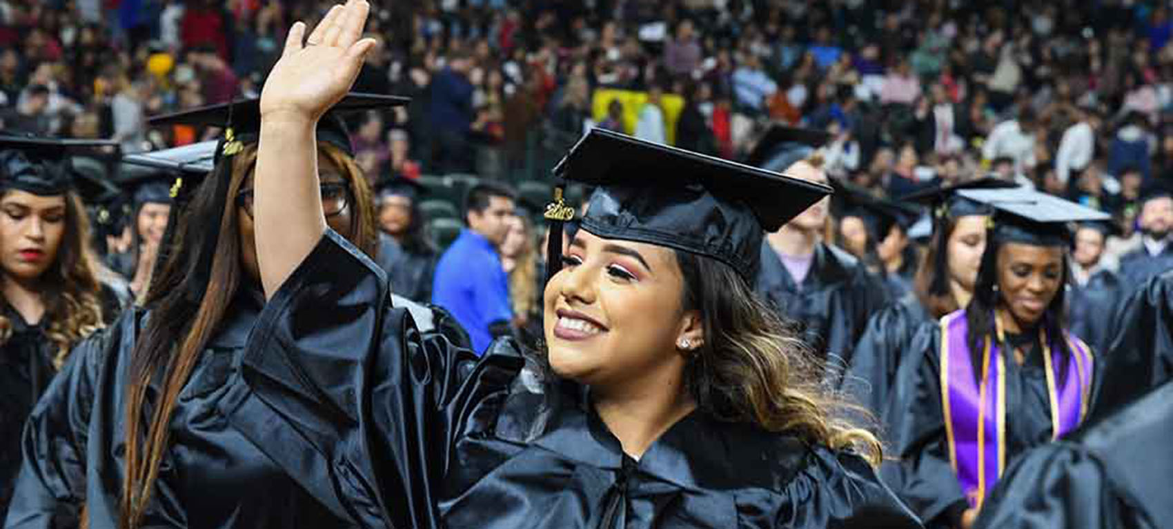 graduate smiling and waving