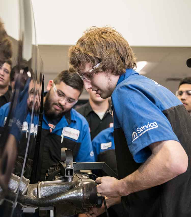 mopar cap student working on side of car