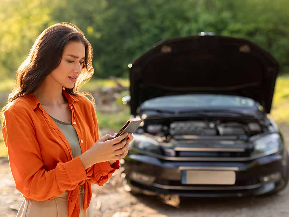 woman with car broken down calling for help