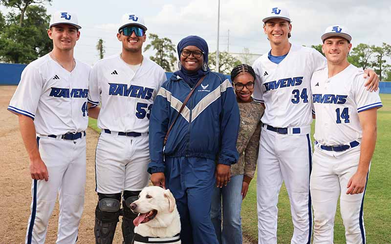 Air Force veteran Tonie Marshall surrounded by her daughter and San Jacinto College baseball players